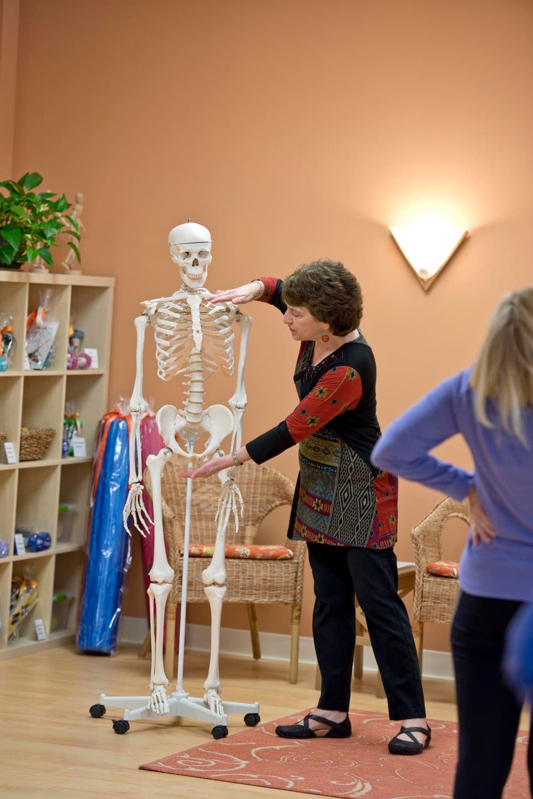 Joanne using an anatomical skeleton to explain where posture loads the spine